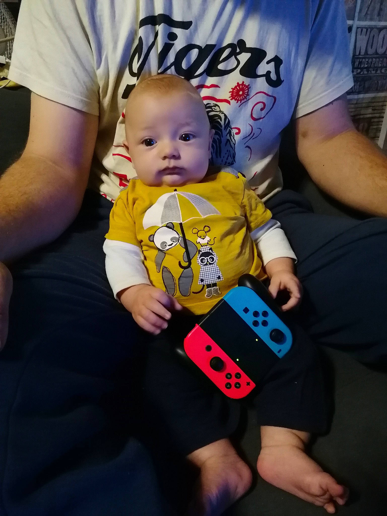 Ezekyel participe au concours pour gagner de l'argent avec cette photo : baby, baby_toddler_clothing, child, communication_device, cool, event, finger, flooring, fun, happy, hat, logo, person, photo_caption, play, recreation, sitting, sleeve, t_shirt, thumb