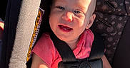 Amiyah is registered to the contest to win money with this photo: arm, baby, car_seat, child, cute, happy, head, indoors, infant, person, pink_clothing, safety_harness, seat, seatbelt, shadow, skin, smiling, sunlight, warning_label, young_child