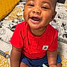 Dallas joined the competition — help win amazing prizes! baby, smiling, red_shirt, blue_shorts, pacifier, indoor, bed, patterned_bedspread, happy, child, infant, cute, sitting, person, closeup, skin, face, hand, foot, toy