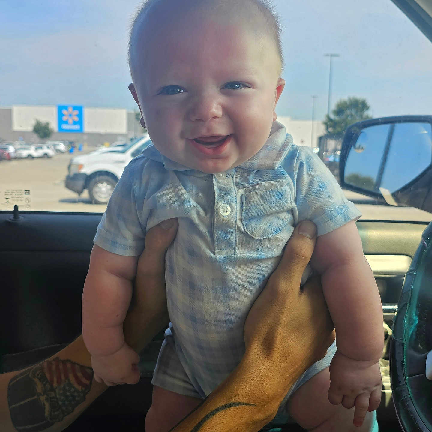 Colton is registered to the contest to win money with this photo: baby, bodypart, car, clothing, face, finger, footwear, hand, head, pants, person, photography, portrait, sedan, sitting, skin, suv, tattoo, transportation, vehicle