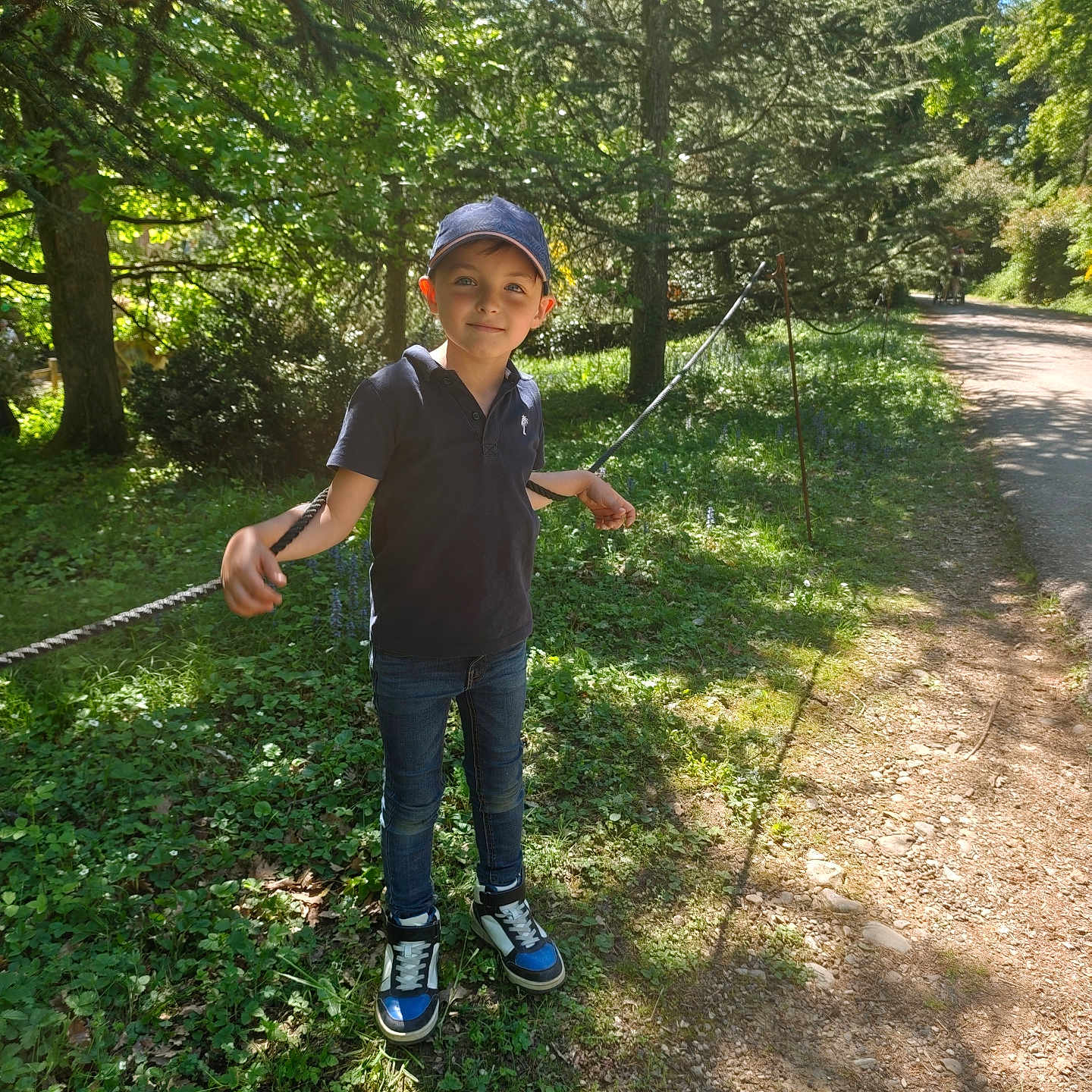 Enzo participe au concours pour gagner de l'argent avec cette photo : boy, cap, casual, child, daylight, forest, grass, greenery, jeans, nature, outdoor, path, recreation, rope, shadow, smile, sneakers, sunlight, trees, young
