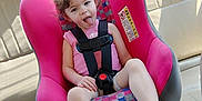 Freyja joined the competition — help win amazing prizes! beige_seat, car_interior, car_seat, casual, child, curly_hair, happy, pink, playful, portrait, safety_harness, sandal, seatbelt, sitting, smiling, summer_clothing, sunlight, tongue_out, vehicle, young_child
