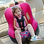 beige_seat, car_interior, car_seat, casual, child, curly_hair, happy, pink, playful, portrait, safety_harness, sandal, seatbelt, sitting, smiling, summer_clothing, sunlight, tongue_out, vehicle, young_child