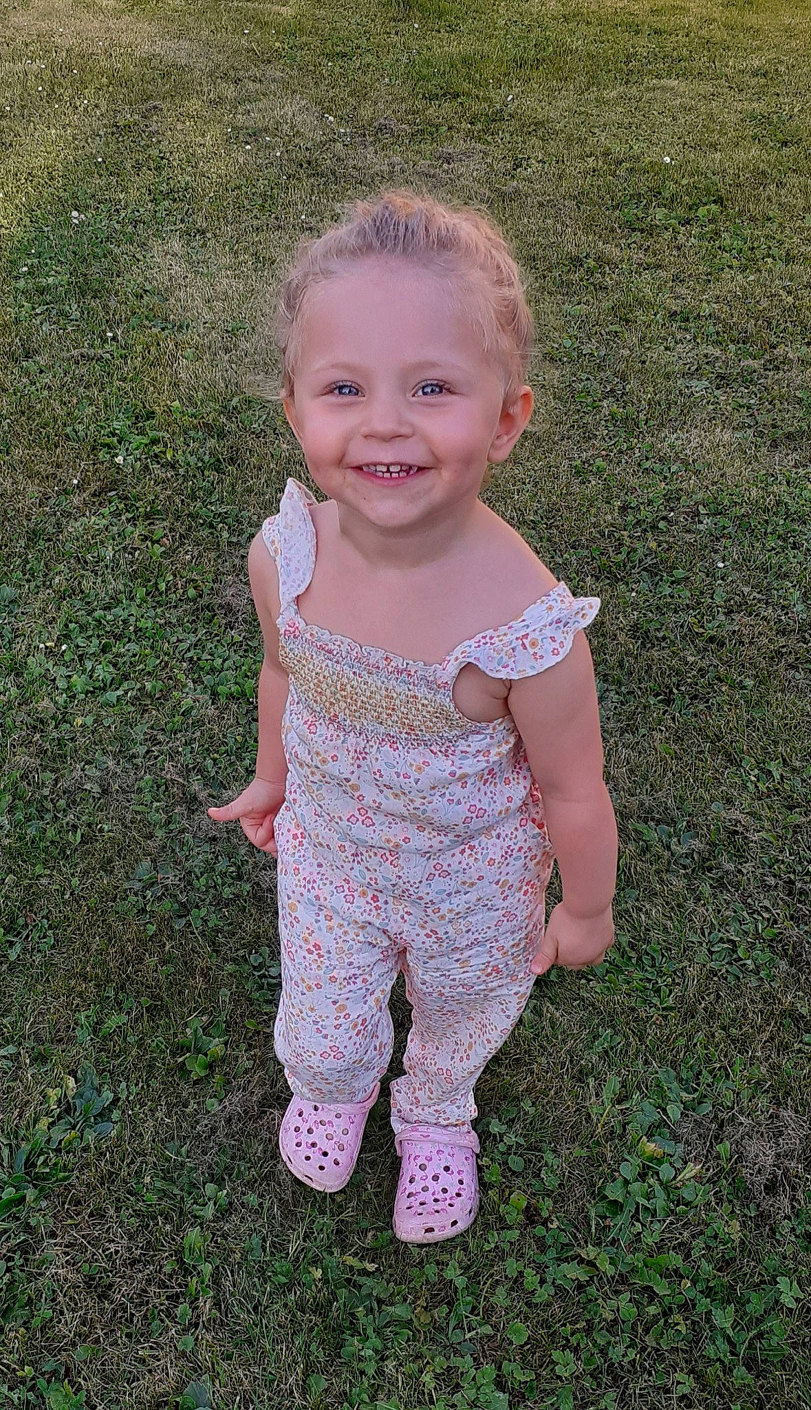 Apoline participe au concours pour gagner de l'argent avec cette photo : arm, baby, baby_toddler_clothing, child, face, fun, grass, grass_family, grassland, happy, head, human_body, joy, lawn, pattern, people_in_nature, person, sitting, sleeve, smile