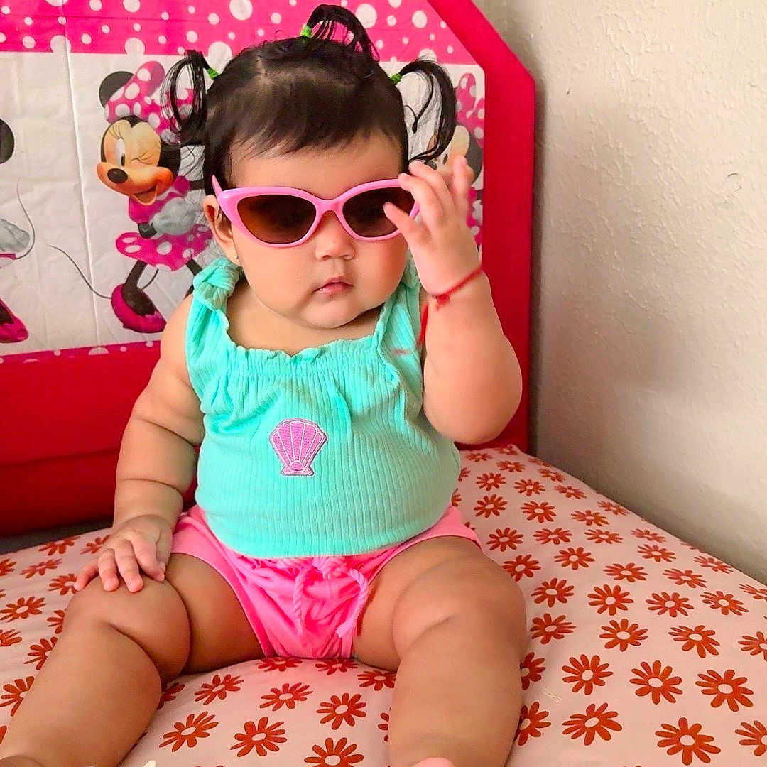 Sharlotte joined the competition — help win amazing prizes! accessory, baby, child, cushion, cute, fashion, floral_pattern, foot, hand, indoor, minnie_mouse, pacifier, pigtails, pink_shorts, portrait, seated, sunglasses, toddler, turquoise_top, wall
