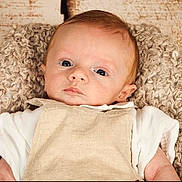 Marceau participe au concours pour gagner de l'argent avec cette photo : baby, infant, blanket, knitted, clothing, beige, white, face, portrait, person, young_child, cute, eyes, head, soft_texture, indoors, resting, cozy, newborn, expression