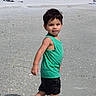 Caleb joined the competition — help win amazing prizes! child, beach, sand, barefoot, green_tank_top, black_shorts, walking, daytime, outdoor, palm_trees, umbrella, people, vacation, sunny, summer, shore, holiday, relaxation, casual_clothing, smiling