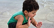 Caleb joined the competition — help win amazing prizes! child, toddler, beach, water, splashing, waves, sand, ocean, playful, summer, barefoot, green_shirt, black_shorts, wet_hair, outdoor, nature, fun, happy, crouching, sea