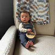 Myles joined the competition — help win amazing prizes! baby, infant, child, armchair, blanket, knit_blanket, plaque, wooden_plaque, three_months, blue_overall, long_sleeve_shirt, animal_print, bare_feet, curious_expression, indoor, cozy, soft_textures, person, portrait, seated