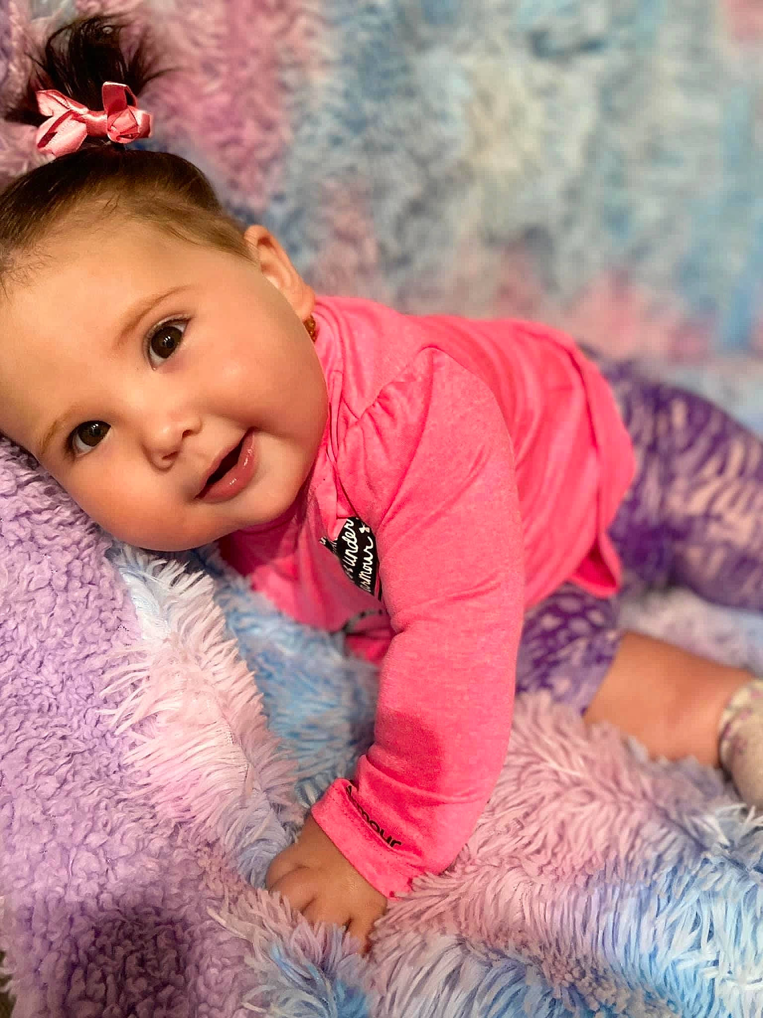 Everleigh is registered to the contest to win money with this photo: baby, baby_toddler_clothing, cheek, child, eyelash, fashion_accessory, grass, happy, human_body, iris, linens, lip, magenta, pattern, person, pink, skin, sleeve, t_shirt, textile