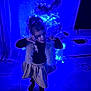 Ambre participe au concours pour gagner de l'argent avec cette photo : child, girl, christmas_tree, holiday_lights, indoor, floor_tiles, curtain, television, furniture, black_tops, skirt, vest, playful_pose, blue_lighting, decorations, living_room, smiling, person, cute, festive