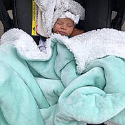 Ambre a rejoint le concours — aidez-le/la à gagner de superbes lots ! baby, blanket, bow, car_seat, child, clothing, comfort, cozy, cute, face, fur, headband, infant, outdoor, peaceful, person, rest, sleeping, soft, wrapped