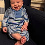 baby, infant, child, smiling, sitting, striped_clothing, blue_clothing, onesie, armchair, blanket, toes, feet, happy, portrait, indoor, cozy, knit, window_blinds, skin, hand