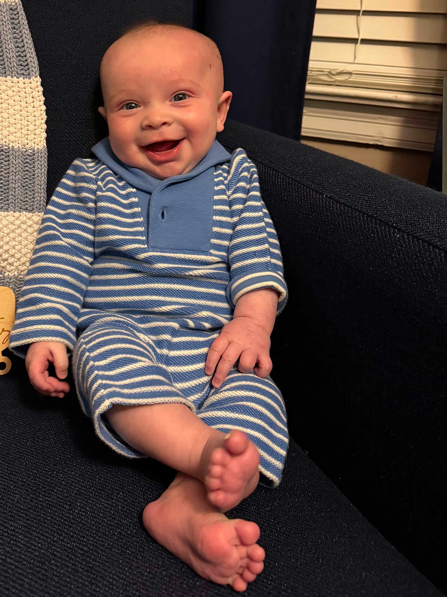 Henry joined the competition — help win amazing prizes! baby, infant, child, smiling, sitting, striped_clothing, blue_clothing, onesie, armchair, blanket, toes, feet, happy, portrait, indoor, cozy, knit, window_blinds, skin, hand