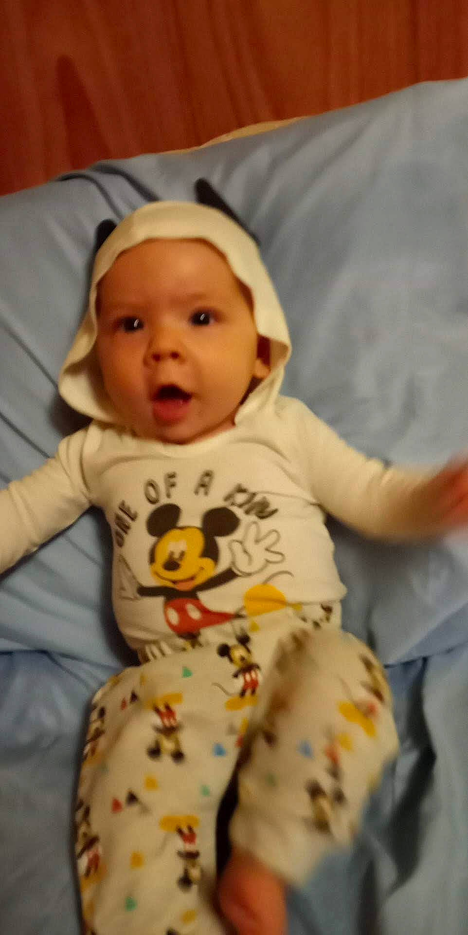 Emery is registered to the contest to win money with this photo: baby, baby_toddler_clothing, cheek, child, chin, comfort, face, fun, happy, hat, linens, nightwear, pajamas, pattern, person, sitting, skin, sleeve, smile, surprise