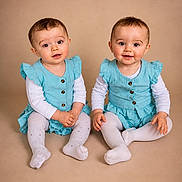 Ilyanna Et Ayanna participe au concours pour gagner de l'argent avec cette photo : baby, blue_dress, child, curious, cute, expression, feet, floor, hands, indoor, light_skin, matching_outfits, portrait, short_hair, sitting, smiling, studio, toddler, twins, white_tights
