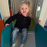 Catalyna a rejoint le concours — aidez-le/la à gagner de superbes lots ! blonde_hair, candid, cardigan, child, cute, happy, indoor_play, jeans, light, missing_tooth, play_equipment, playground, portrait, sitting, slide, smile, socks, toddler, window, wooden_panel