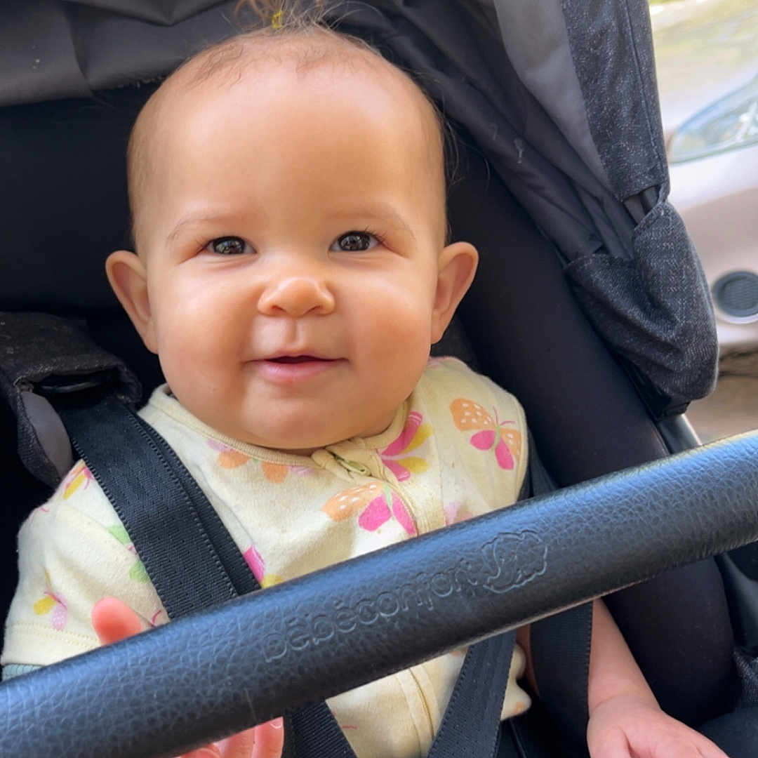 Rose a rejoint le concours — aidez-le/la à gagner de superbes lots ! baby, babygear, butterfly_pattern, car, child, clothing, cute, daylight, face, hand, happy, head, infant, onesie, outdoor, person, safety_harness, seatbelt, smile, stroller