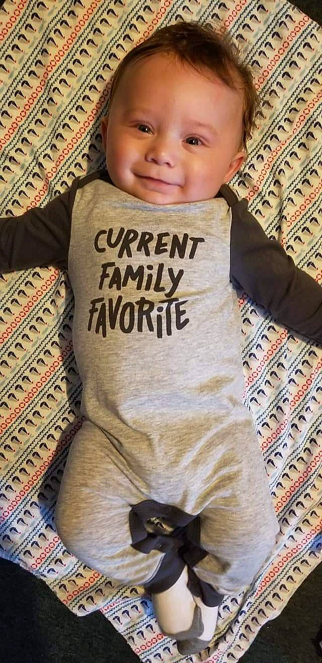 Tylin is registered to the contest to win money with this photo: baby, baby_products, baby_toddler_clothing, child, font, infant_bodysuit, outerwear, pattern, person, product, sleeve, smile, t_shirt, toddler