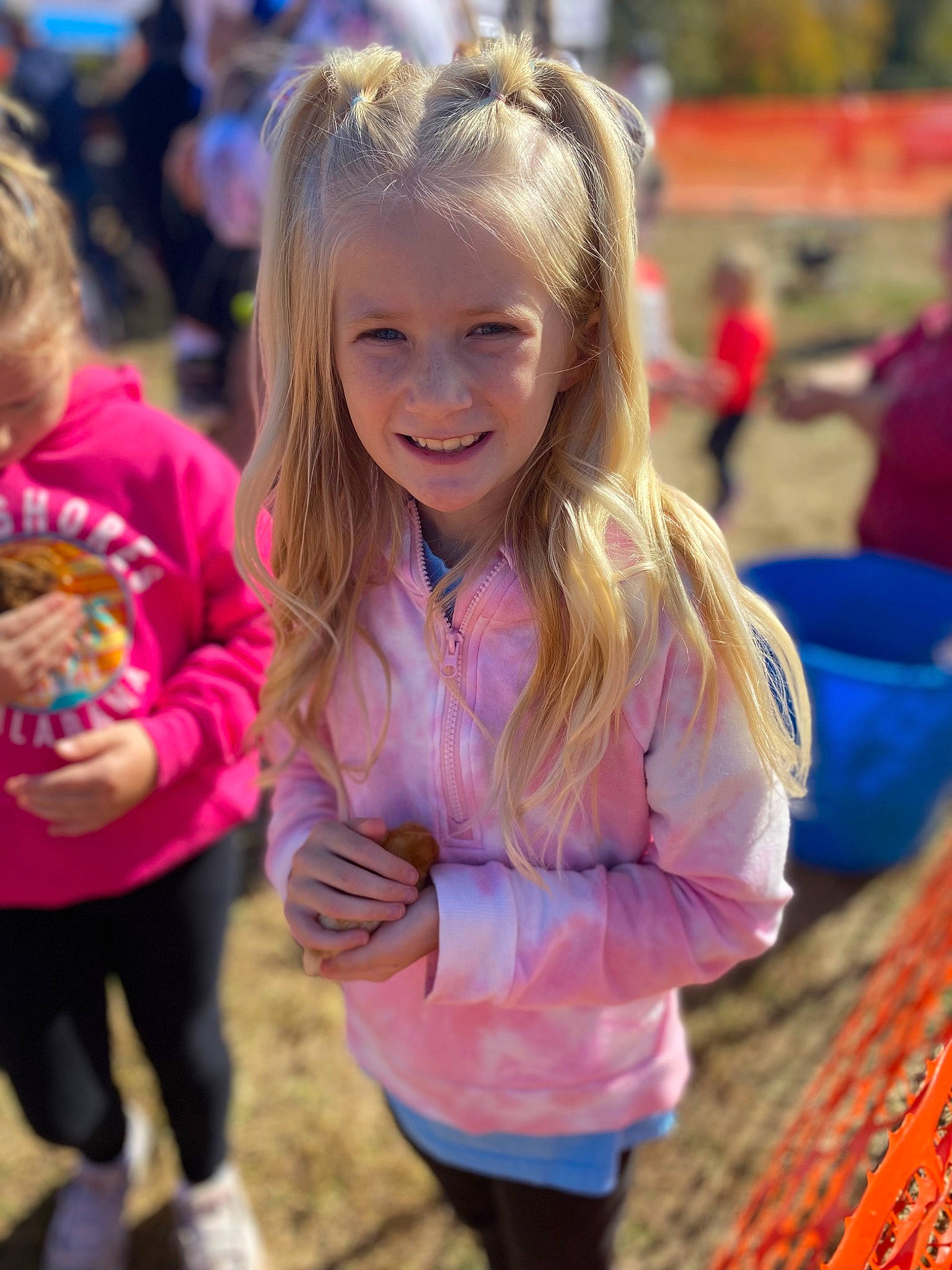 Kenzie Jo is registered to the contest to win money with this photo: blond, brown_hair, child, event, fun, grass, hair, hairstyle, happy, head, iris, joy, leisure, magenta, mammal, person, pink, public_space, recreation, sitting