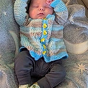 Elijah joined the competition — help win amazing prizes! baby, sleeping, knitted_sweater, bee_buttons, blanket, star_pattern, cozy, infant, cute, soft_texture, lying_down, clothing, socks, yellow, blue, gray, relaxed, peaceful, indoors, person