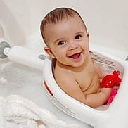 Logan joined the competition — help win amazing prizes! baby, bathtub, bath_seat, bubbles, child, cute, face, happy, infant, inside, person, playful, red_toy, sitting, smile, toy, water, white, young, toddler