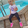Mila a rejoint le concours — aidez-le/la à gagner de superbes lots ! child, girl, braids, blonde_hair, white_tshirt, nike, black_pants, pink_sneakers, pool, wooden_deck, outdoor, summer, smiling, casual, sitting, young, backyard, trees, fence, concrete