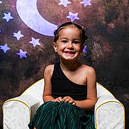 Mila participe au concours pour gagner de l'argent avec cette photo : child, girl, smile, chair, black_top, green_skirt, portrait, studio, moon, stars, background, happiness, posing, fashion, cute, young, sitting, indoor, decor, happy