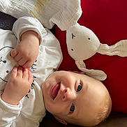 Wyatt a rejoint le concours — aidez-le/la à gagner de superbes lots ! baby, bunny, child, couch, cozy, cute, expression, face, hands, happy, indoor, infant, lying_down, plush_toy, portrait, red_cushion, smiling, soft_toy, white_clothing, young_child