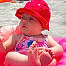 baby, infant, beach, sand, sunhat, red_hat, swimsuit, inflatable_ring, pink, feet, child, summer, outdoor, relaxed, cute, sunny, vacation, toy_bucket, play, leisure