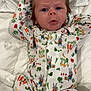 Logan is registered to the contest to win money with this photo: baby, infant, onesie, cartoon_print, vegetables, bunny, cute, sleepwear, soft_blanket, lying_down, curious_expression, spiky_hair, indoors, child, portrait, closeup, white_background, comfortable, cozy, person
