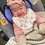 baby, infant, smile, car_seat, headband, bow, bib, blanket, mittens, clothing, face, person, cute, happy, indoors, child, warm, seat, fabric, texture