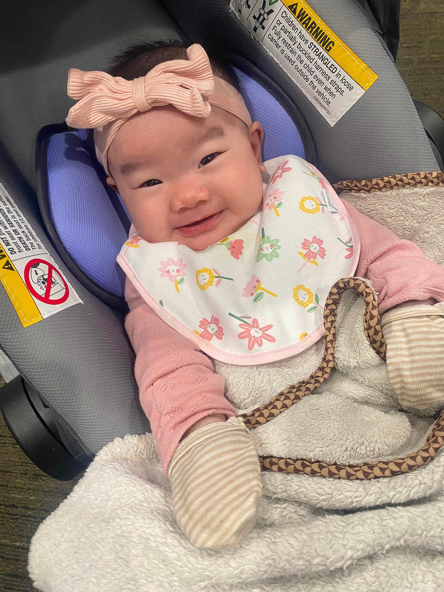 Jasmine joined the competition — help win amazing prizes! baby, infant, smile, car_seat, headband, bow, bib, blanket, mittens, clothing, face, person, cute, happy, indoors, child, warm, seat, fabric, texture