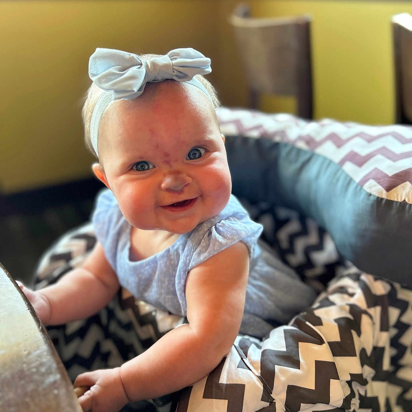 Arabella is registered to the contest to win money with this photo: baby, babylaughing, blonde, clothing, couch, cushion, dress, face, furniture, happy, head, homedecor, laughing, newborn, pants, person, photography, portrait, sitting, smile