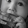 baby, child, black_and_white, close_up, face, hands, food, biscuit, snack, cute, eyes, portrait, infant, soft_lighting, texture, expression, young_child, monochrome, clothing, munching