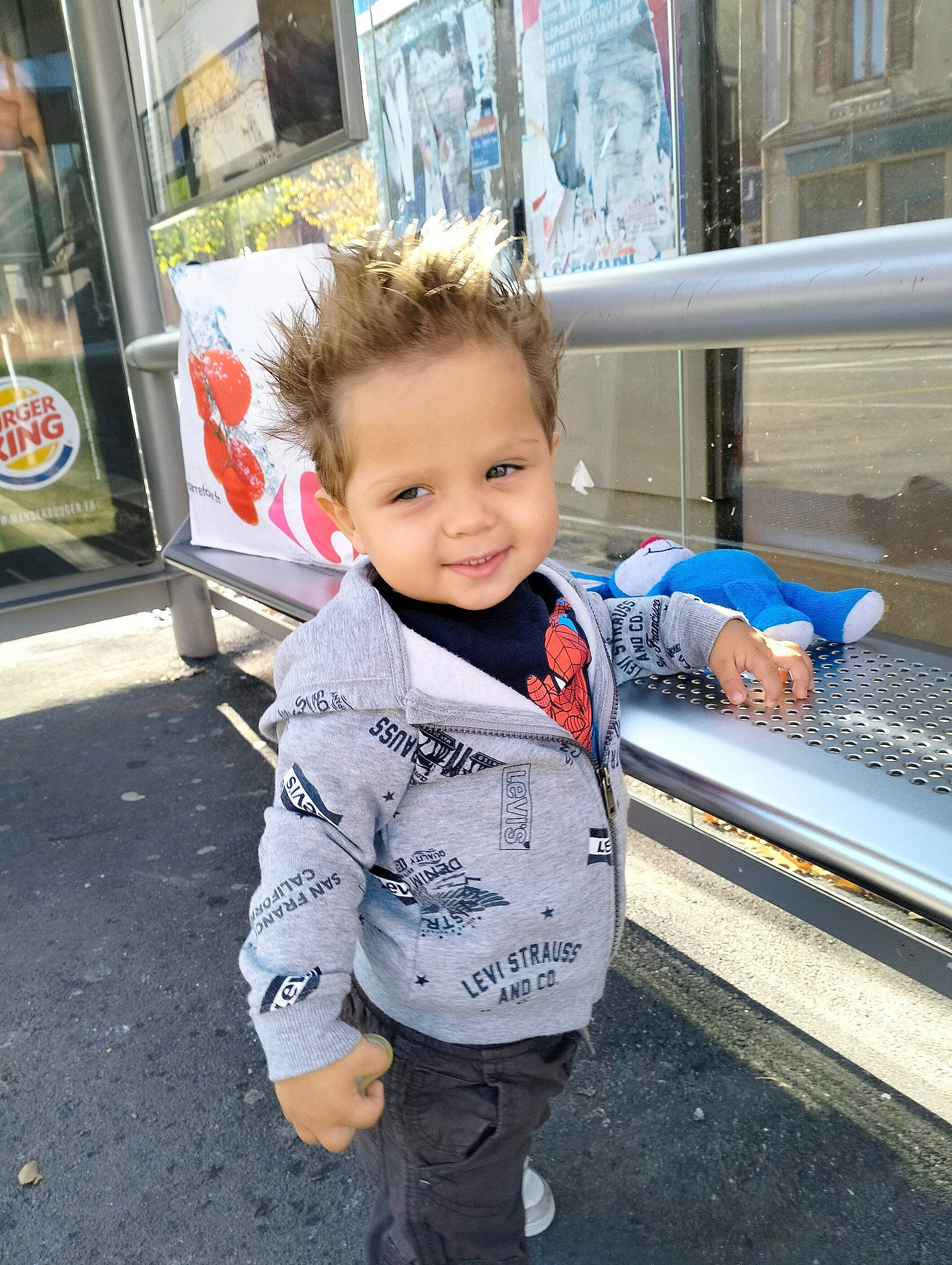 Marlon a rejoint le concours — aidez-le/la à gagner de superbes lots ! asphalt, baby, baby_toddler_clothing, child, city, denim, electric_blue, fun, happy, joy, leisure, pedestrian, person, sitting, smile, street, toddler, tourism, travel, vacation