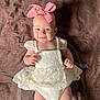 Lily joined the competition — help win amazing prizes! baby, infant, smile, headband, pink_bow, lace_dress, white_clothing, cute, lying_down, blanket, brown_background, happy, child, portrait, small_hands, blue_eyes, soft_lighting, indoors, person, fashion