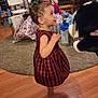 Emersyn joined the competition — help win amazing prizes! toddler, child, plaid_dress, green_bow, barefoot, wooden_floor, stuffed_animal, christmas_tree, christmas_lights, presents, gift_bags, living_room, carpet, chair, holiday, holiday_decor, curious, indoors, smiling, celebration