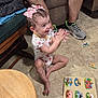 adult, animal_puzzle, bow, chair, child, clapping, family, floor, hair_bow, happy, indoors, playtime, puzzle, shorts, smiling, sneakers, table, tile_floor, toddler, wooden_table