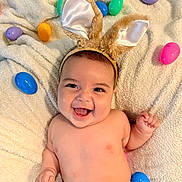 Mateo is registered to the contest to win money with this photo: baby, bunny_ears, smiling, laughing, easter_eggs, colorful, blanket, infant, cute, happy, soft_texture, playful, headband, child, indoors, skin, cheerful, lying_down, holiday, festive