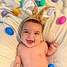 baby, bunny_ears, smiling, laughing, easter_eggs, colorful, blanket, infant, cute, happy, soft_texture, playful, headband, child, indoors, skin, cheerful, lying_down, holiday, festive