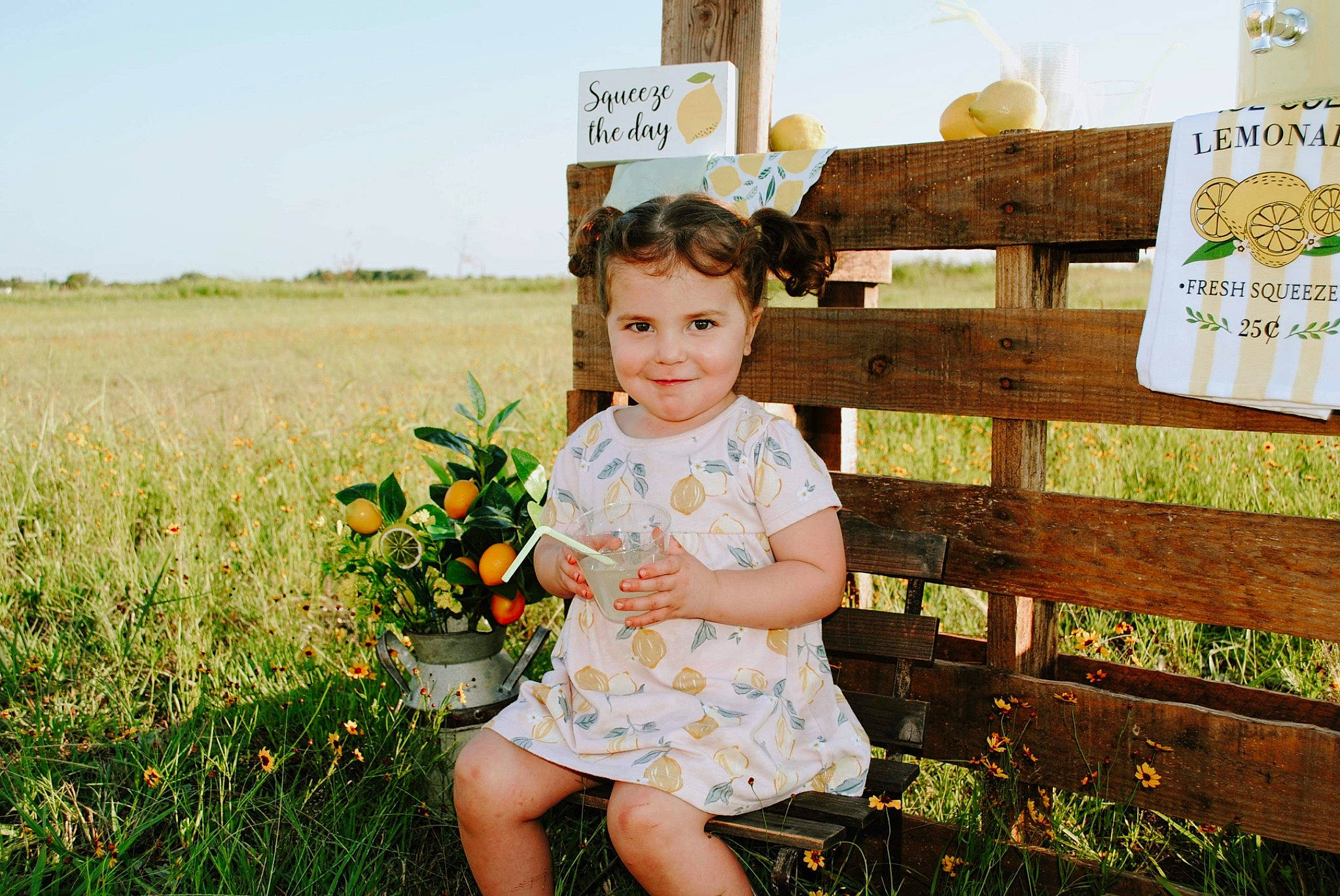 Grace joined the competition — help win amazing prizes! child, fence, flower, fun, grass, grassland, happy, joy, landscape, leisure, people_in_nature, person, plant, prairie, sitting, sky, spring, summer, t_shirt, toddler
