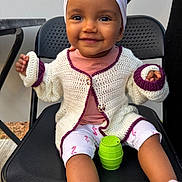 Safiya a rejoint le concours — aidez-le/la à gagner de superbes lots ! baby, black_chair, chair, child, closeup, cute, fashion, green_toy, happy, head_wrap, indoor, knitted_cardigan, leggings, pink_clothing, playful, portrait, seated, smiling, toddler, toy