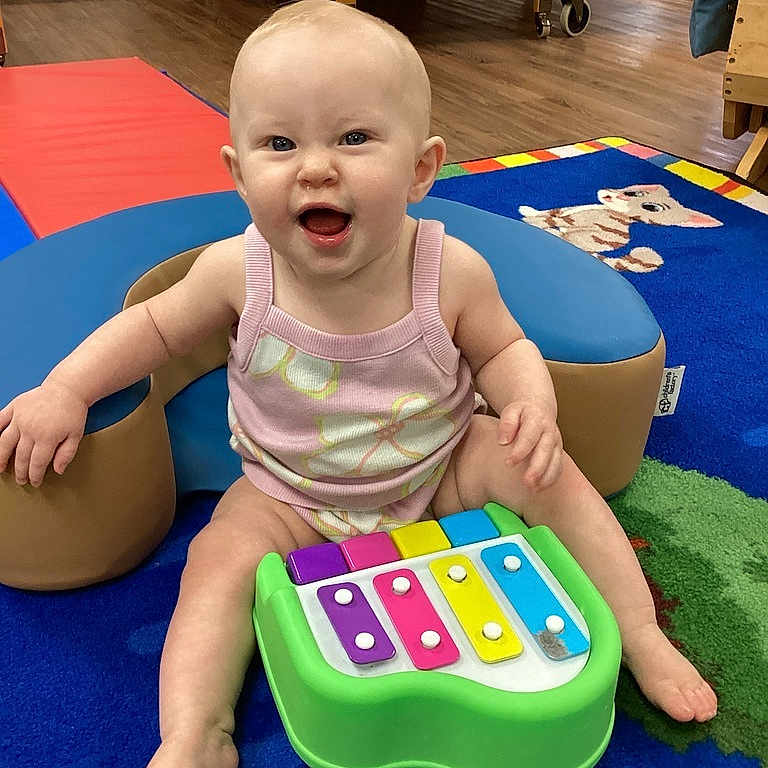Giavanna is registered to the contest to win money with this photo: baby, child, infant, smiling, happy, sitting, toy, xylophone, music, nursery, playroom, colorful, rug, crib, indoor, portrait, barefoot, pink_outfit, playtime, joy