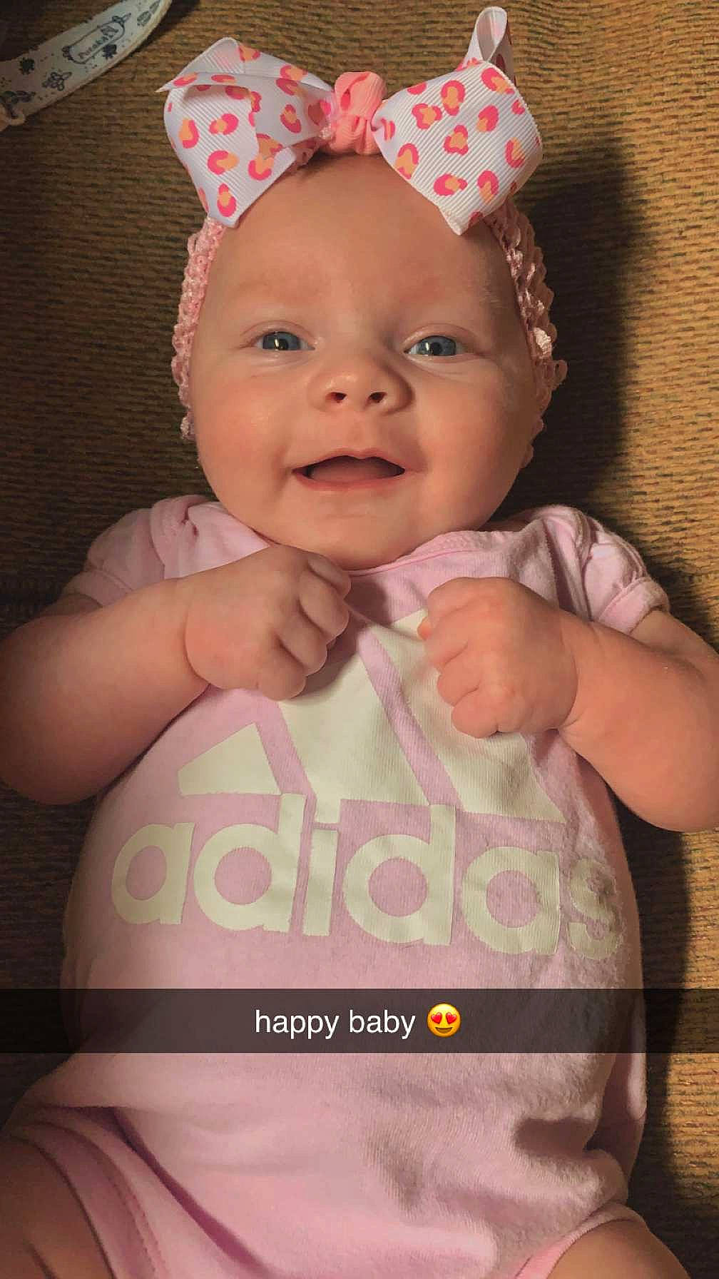 Cora is registered to the contest to win money with this photo: baby, baby_toddler_clothing, cap, child, costume_hat, fashion_accessory, finger, fun, gesture, happy, headpiece, headwear, lip, magenta, party_supply, peach, person, pink, product, smile