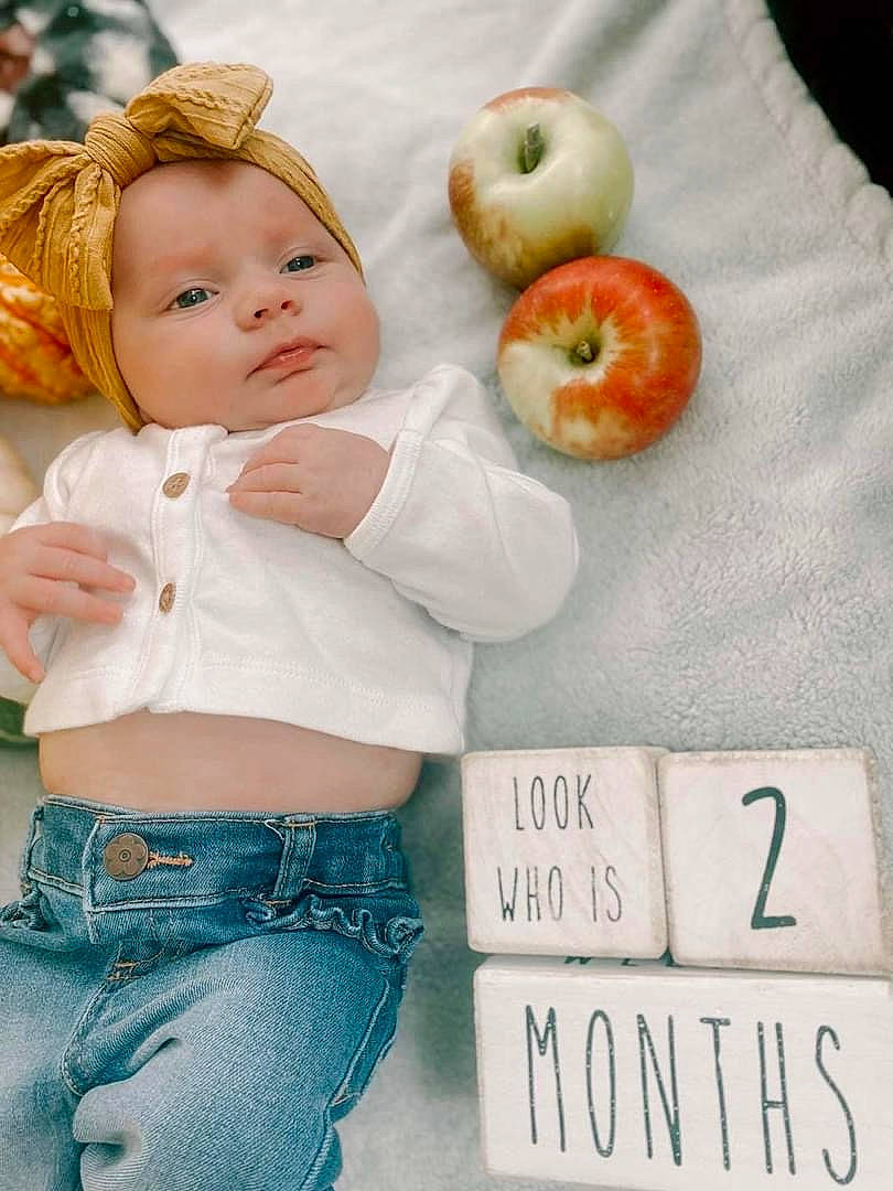 Cora is registered to the contest to win money with this photo: abdomen, apple, baby, baby_toddler_clothing, belt, child, fruit, happy, ingredient, mcintosh, natural_foods, pattern, people_in_nature, person, plant, produce, product, recipe, superfood, toddler