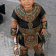 Juan joined the competition — help win amazing prizes! child, costume, aztec, feathers, headgear, armbands, concrete, street, traditional, cultural, footwear, toy, young, portrait, standing, outdoor, decorative, patterned, accessories, expression