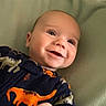 Silas joined the competition — help win amazing prizes! baby, infant, smiling, dinosaur_onesie, blanket, plush_toy, green_toy, happy, lying_down, cute, child, portrait, indoors, cozy, soft_texture, young_child, baby_clothing, infant_face, baby_hand, playpen