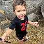 Keion joined the competition — help win amazing prizes! black_shirt, casual_clothing, child, curly_hair, exploring, grass, happy, nature, outdoor, person, playful, red_numbers, rocks, sandals, shorts, smiling, stick, summer, toddler, young