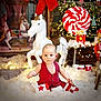 Léo a rejoint le concours — aidez-le/la à gagner de superbes lots ! baby, child, red_outfit, christmas_lights, carousel_horse, nutcracker, candy_cane, holiday_decor, festive, snow_like_cotton, toy, christmas_tree, red_and_white, gift_box, sitting, indoor, holiday_scene, cute, festivity, decorations